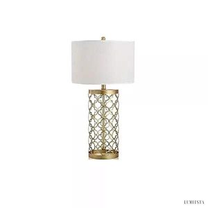 Złota metalowa lampa stołowa ażurowa - widok z lekkiej perspektywy na geometryczny korpus