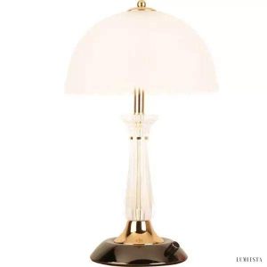 Lampa stołowa szklana z kloszem muszlą — przezroczysty trzonek mosiężny i mleczna obudowa na białym tle