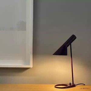 Biała asymetryczna lampa stołowa z metalu - ujęcie z lekkiego skosu