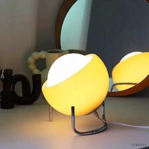 Pomarańczowa lampa stołowa Bauhaus z kulistym kloszem, ujęcie pod lekkim kątem