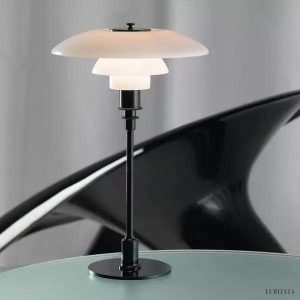 Lampa stołowa biała z wielowarstwowym kloszem, ujęcie z boku na łagodne łuki