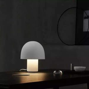 Lampa stołowa kształt grzyba nowoczesna — szary abażur i biała podstawa na czarnym biurku