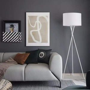 Czarna lampa stojąca LED na trójnogu do salonu, zbliżenie na klosz i linię oprawy
