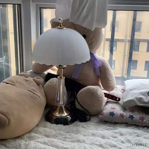 Lampa stołowa z białym, muszelkowym kloszem i złotą podstawą - widok z boku