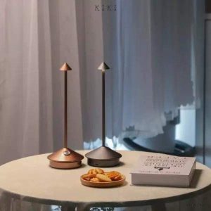 Nowoczesna lampa stołowa LED z akumulatorem, widok na smukłą metalową podstawę i stożek