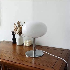 Biała owalna lampa stołowa Bauhaus na jasnym tle, widok z przodu