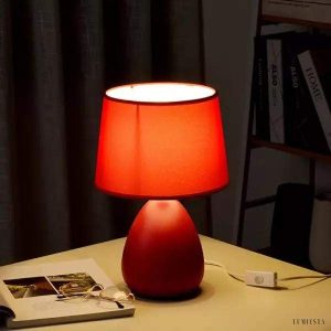 Kolorowa ceramiczna lampa stołowa z wyraźnie profilowaną podstawą i dekoracyjnym wykończeniem