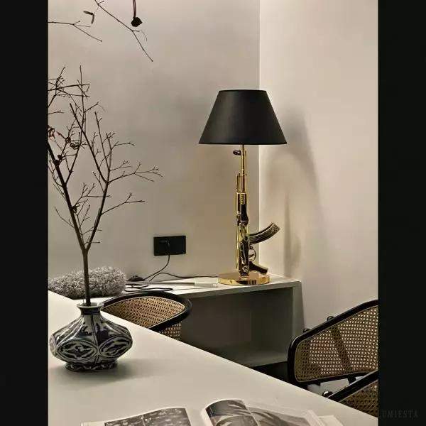 Lampa biurkowa w kształcie pistoletu, detal złotego wykończenia metalu