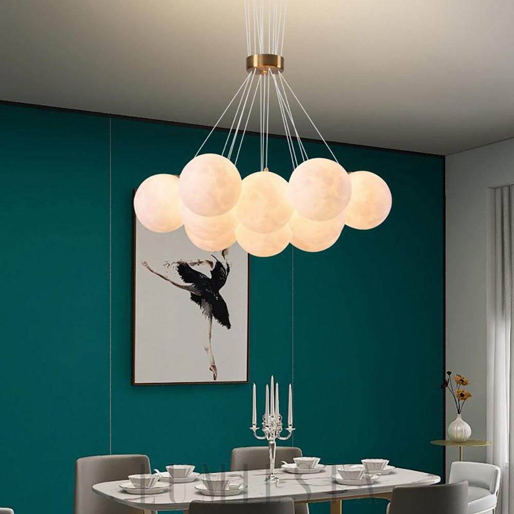 Lunaris - lampa wisząca alabastrowa kule, widok na kilka kul rozświetlonych miękkim światłem