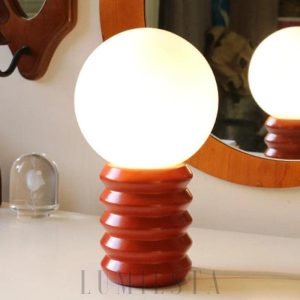Nowoczesna lampa stołowa z okrągłym kloszem i stojakiem, aranżacja na stoliku
