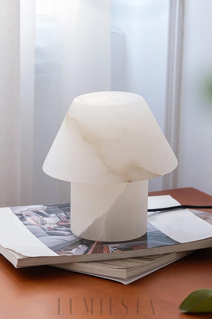 Lampa stołowa Petra z alabastru biała stożkowa, sylwetka lampy podkreślona miękkim światłem
