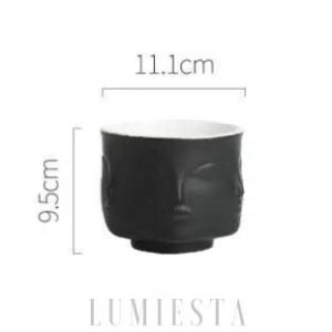 Ceramiczna doniczka w kształcie twarzy złoto czarna z wyraźnie zaznaczonymi rysami twarzy