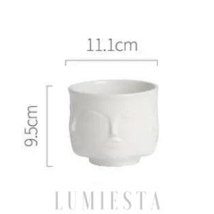 Ceramiczna doniczka w kształcie twarzy złoto czarna w dekoracyjnym ujęciu z przodu i z boku