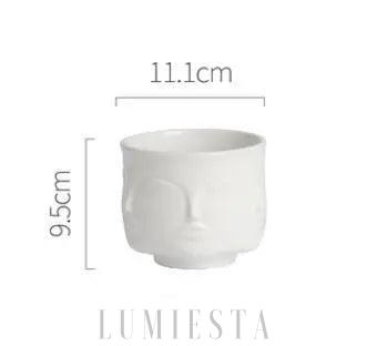 Ceramiczna doniczka w kształcie twarzy złoto czarna w dekoracyjnym ujęciu z przodu i z boku