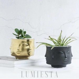 Ceramiczna doniczka w kształcie twarzy złoto czarna z wyraźnym profilem i gładkim połyskiem