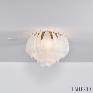 Unico - detal złotej lampy sufitowej ze szklanym kloszem, widok z bliska