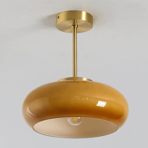 Formlicht - detal mosiężnego mocowania i pomarańczowego klosza szklanego w stylu Bauhaus